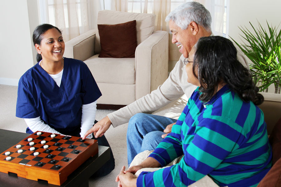 Caregiver sitting with a senior man offering companionship and emotional support at home in the Greater Hartford Area, CT